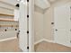 Functional laundry room with tile flooring, ample shelving, and convenient access to storage space at 2120 Gwynhurst Blvd, Wesley Chapel, FL 33543