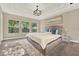 Primary bedroom featuring a king bed, tray ceilings, large windows and neutral paint at 2120 Gwynhurst Blvd, Wesley Chapel, FL 33543