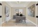 Stylish home office featuring a desk, artwork, and natural light from two windows at 2120 Gwynhurst Blvd, Wesley Chapel, FL 33543