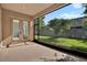 Screened patio with double doors and offering views of the green lawn and fenced yard at 2120 Gwynhurst Blvd, Wesley Chapel, FL 33543