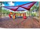 View of the community playground with colorful equipment and sun shade for enjoyable outdoor activities at 2120 Gwynhurst Blvd, Wesley Chapel, FL 33543