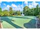 View of a community tennis court featuring green court and beautiful surrounding landscaping at 2120 Gwynhurst Blvd, Wesley Chapel, FL 33543