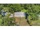 An aerial view showcases the home, the yard, shed, and surrounding verdant landscaping and neighborhood at 2121 Odessa Gardens Ln, Odessa, FL 33556