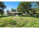 View of the home's exterior and backyard featuring mature trees and natural landscaping at 2121 Odessa Gardens Ln, Odessa, FL 33556