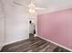 This bedroom includes woodgrain vinyl floors, closet and light ceiling fan at 2121 Odessa Gardens Ln, Odessa, FL 33556
