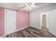 This bedroom includes woodgrain vinyl floors, closet and light ceiling fan at 2121 Odessa Gardens Ln, Odessa, FL 33556
