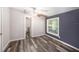 Bedroom with wood-look floors, a dark accent wall, a window, and an en-suite bathroom at 2121 Odessa Gardens Ln, Odessa, FL 33556