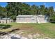 Charming single-story home with brown siding, complemented by lush greenery, a shed and blue window shutters at 2121 Odessa Gardens Ln, Odessa, FL 33556