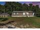 Charming single-story home with brown siding, complemented by lush greenery, a shed and blue window shutters at 2121 Odessa Gardens Ln, Odessa, FL 33556