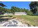 A cozy single-story home with brown siding, complemented by lush greenery, a shed and blue window shutters at 2121 Odessa Gardens Ln, Odessa, FL 33556