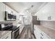 Modern kitchen with stainless steel appliances, granite countertops, and sleek, white cabinets at 2121 Odessa Gardens Ln, Odessa, FL 33556