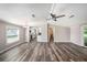 Open-concept living area with wood-look flooring and views of the kitchen, window, and sliding glass doors at 2121 Odessa Gardens Ln, Odessa, FL 33556