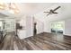 Open-concept living room featuring a ceiling fan, hardwood floors, and sliding glass doors to the outside at 2121 Odessa Gardens Ln, Odessa, FL 33556