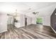 Open-concept living area with wood-look flooring and a view of the kitchen and sliding glass doors at 2121 Odessa Gardens Ln, Odessa, FL 33556
