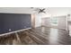 Open-concept living area showcasing wood-look flooring, a dark accent wall, and a nearby kitchen at 2121 Odessa Gardens Ln, Odessa, FL 33556