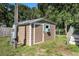 An outdoor storage outbuilding with horizontal siding, a single door, and a small air conditioning unit at 2121 Odessa Gardens Ln, Odessa, FL 33556