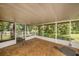 Covered screened porch featuring unfinished wood floor and a beautiful view of the wooded backyard at 2121 Odessa Gardens Ln, Odessa, FL 33556