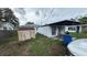 Exterior backyard of home with weathered shed, blue accents, and a Personal sitting at a picnic table at 2410 38Th N Ave, St Petersburg, FL 33713
