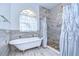 Bathroom featuring a standalone tub with a tiled shower with pebble flooring and elegant sheer curtains at 2504 Oak Landing Dr, Brandon, FL 33511