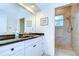 Bright bathroom featuring a tiled shower and a white vanity with a black countertop and chrome fixtures at 2504 Oak Landing Dr, Brandon, FL 33511
