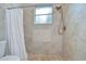 Tiled shower featuring an adjustable shower head, a built-in niche, and a curtained half wall at 2504 Oak Landing Dr, Brandon, FL 33511
