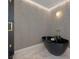 Elegant bathroom featuring a modern black standalone tub, stylish fixtures, and textured walls at 3197 Walnut Ne St, St Petersburg, FL 33704