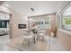 Bright dining room with modern light fixture, fireplace, glass table and view of backyard at 3197 Walnut Ne St, St Petersburg, FL 33704