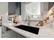 Close up of a kitchen sink featuring a black basin, marble countertop and a gold faucet at 3197 Walnut Ne St, St Petersburg, FL 33704