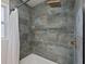 Elegant shower with multi-tone tiled walls, rainfall shower head, and a soaking tub at 3197 Walnut Ne St, St Petersburg, FL 33704