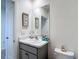 A well-lit half-bathroom vanity features a modern sink, marble countertop and coastal decorations at 34033 Jasper Stone Dr, Wesley Chapel, FL 33543