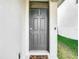 Welcoming dark-colored front door detailed with panels and a transom window, accompanied by a decorative doormat at 34033 Jasper Stone Dr, Wesley Chapel, FL 33543