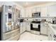 Well-lit kitchen with stainless steel appliances, granite countertops, and white cabinets at 34033 Jasper Stone Dr, Wesley Chapel, FL 33543