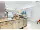 An open kitchen featuring stone countertops and an island sink that looks out into the living room at 34033 Jasper Stone Dr, Wesley Chapel, FL 33543