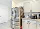Kitchen area showcasing stainless steel fridge and white cabinets with contrasting countertops at 34033 Jasper Stone Dr, Wesley Chapel, FL 33543
