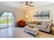Bright living room with an outdoor view featuring a gray sofa and sliding glass doors at 34033 Jasper Stone Dr, Wesley Chapel, FL 33543