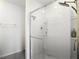 A bright, glass-enclosed walk-in shower features multiple shower heads and built-in shelving at 34033 Jasper Stone Dr, Wesley Chapel, FL 33543