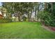 Expansive backyard with lush greenery and a serene view of the lake at 3620 Little Rd, Lutz, FL 33548