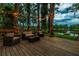 Spacious backyard deck with comfortable seating overlooking the water, beautifully lit with string lights at 3620 Little Rd, Lutz, FL 33548
