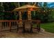 Charming wooden deck with an umbrella-covered dining set and string lights amid a peaceful outdoor setting at 3620 Little Rd, Lutz, FL 33548