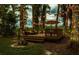 Relaxing backyard deck with comfortable furniture, surrounded by trees and accented with string lights at 3620 Little Rd, Lutz, FL 33548