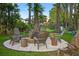 Inviting backyard firepit with chairs, creating a cozy outdoor gathering space at 3620 Little Rd, Lutz, FL 33548