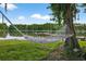 Hammock facing a lake with a dock and seating at 3620 Little Rd, Lutz, FL 33548