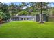 Spacious backyard featuring a screened lanai, storage shed, and lush greenery at 3620 Little Rd, Lutz, FL 33548