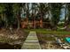 Scenic view from a private dock showcasing the lush backyard, string-lit deck, and serene lake at 3620 Little Rd, Lutz, FL 33548