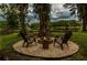 Picturesque backyard fire pit area with Adirondack chairs, ideal for outdoor gatherings by the lake at 3620 Little Rd, Lutz, FL 33548