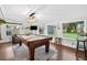 Game room features pool table, tv, and backyard views from multiple windows at 3620 Little Rd, Lutz, FL 33548