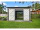 Golf simulator with barn doors in the backyard at 3620 Little Rd, Lutz, FL 33548