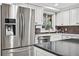 Well-lit kitchen with stainless steel refrigerator, farmhouse sink, and modern backsplash at 3620 Little Rd, Lutz, FL 33548