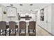 Bright, all-white kitchen featuring a center island, bar stool seating, and modern pendant lighting at 3620 Little Rd, Lutz, FL 33548