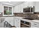 Well-equipped kitchen with stainless steel appliances, white cabinets, and a large window at 3620 Little Rd, Lutz, FL 33548